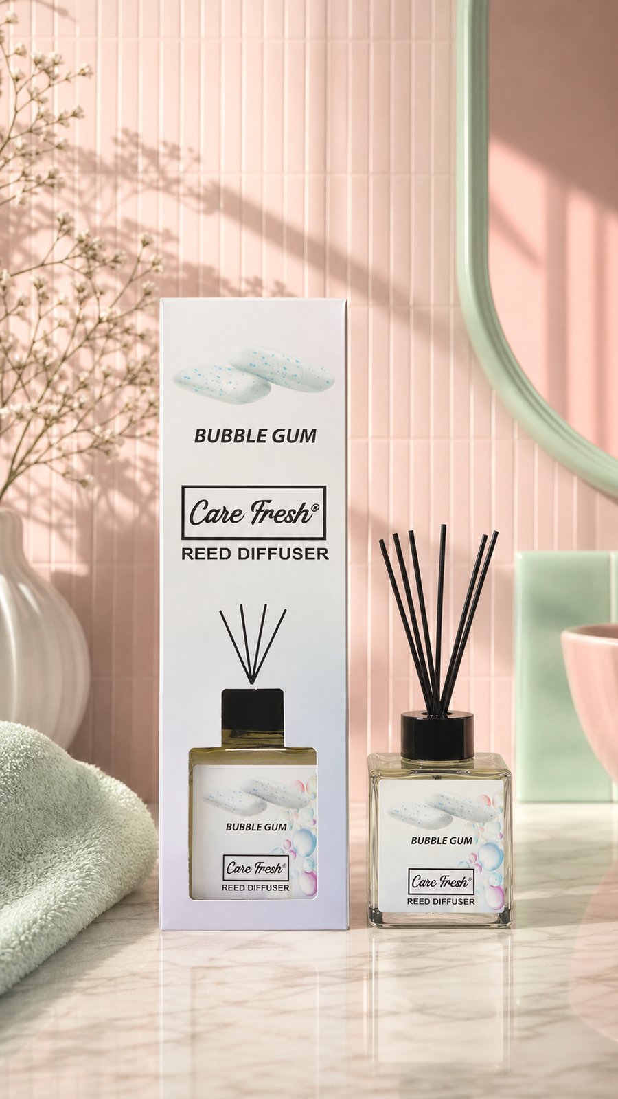 Parfum de cameră cu bețișoare BUBBLE GUM, 85 ml — flaconul de sticlă cu bețișoare de bambus, alături de cutie, într-un interior luminos