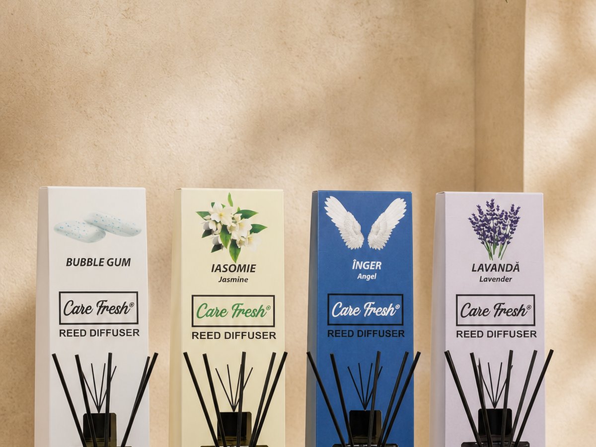 Cutiile celor patru parfumuri de cameră CARE FRESH — bubble gum, iasomie, înger și lavandă — aliniate lângă un perete crem, cu bețișoarele de bambus în flacoane